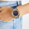 Goudkleurig analoog horloge met blauwe siliconen band