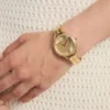 Goudkleurig analoog horloge met driehoekige bandbevestigingen