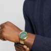 Goudkleurig en groen analoog horloge
